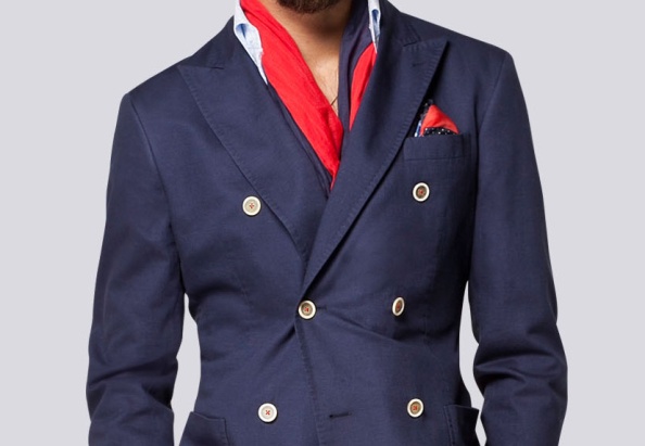 The red thread detailing on the cream horn buttons bring an otherwise typical navy double breasted blazer to life. Pay attention to the pick stitching on the lapels and the patch pockets.